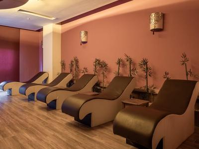Varias tumbonas cómodas en una sala de spa relajante con luz cálida.