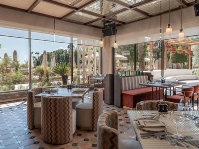 Ristorante moderno con ampie finestre che si affacciano su un'area verde esterna.