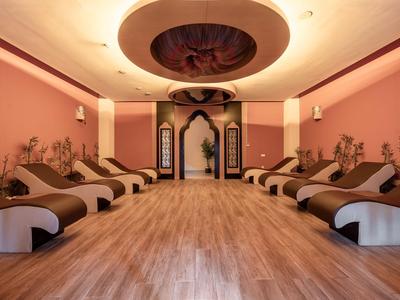 Sala benessere tranquilla con comodi lettini e pavimento in legno caldo in rosa rilassante.
