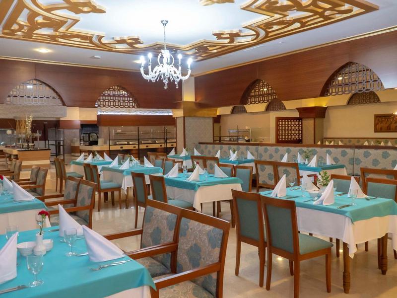 Elegancka restauracja z turkusowymi obrusami i żyrandolem na suficie