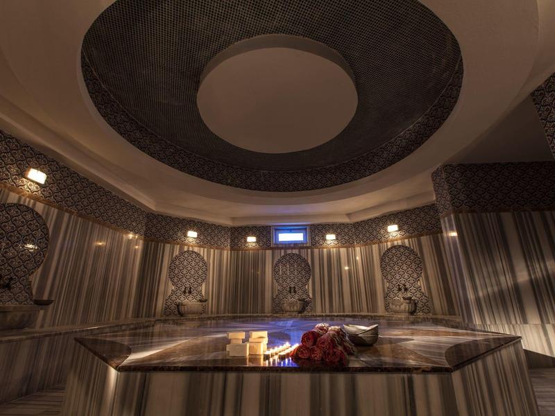 Luksusowe wnętrze z podgrzewanym basenem i artystycznymi elementami na ścianach w przytłumionym świetle