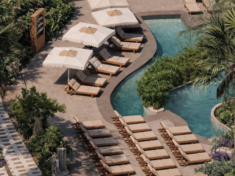 Espace extérieur d'hôtel avec piscine, chaises longues et parasols entouré de verdure.