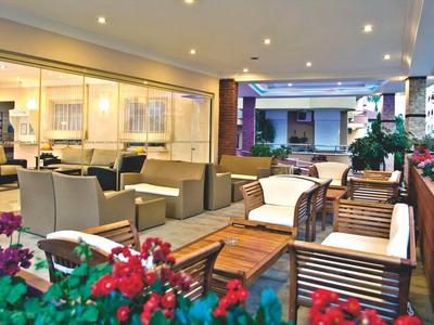 Espace extérieur confortable avec sièges et fleurs sur une terrasse d'hôtel.