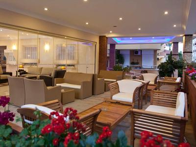 Terrasse moderne avec fauteuils confortables, mobilier en bois et fleurs colorées.