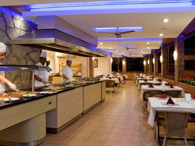 Restaurant moderne avec buffet, longues tables et éclairage élégant.