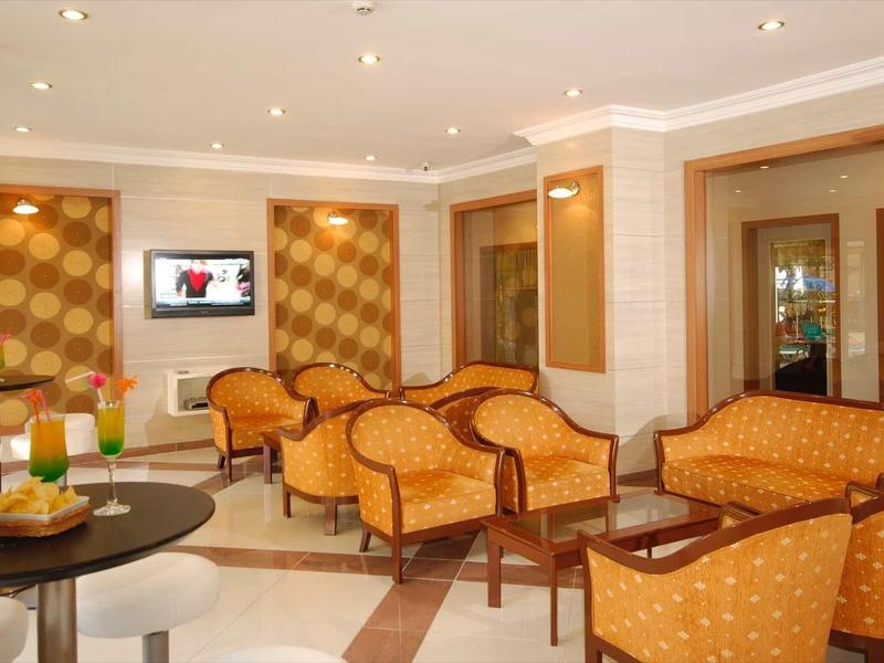 Salon d'hôtel confortable avec fauteuils orange et intérieur moderne.