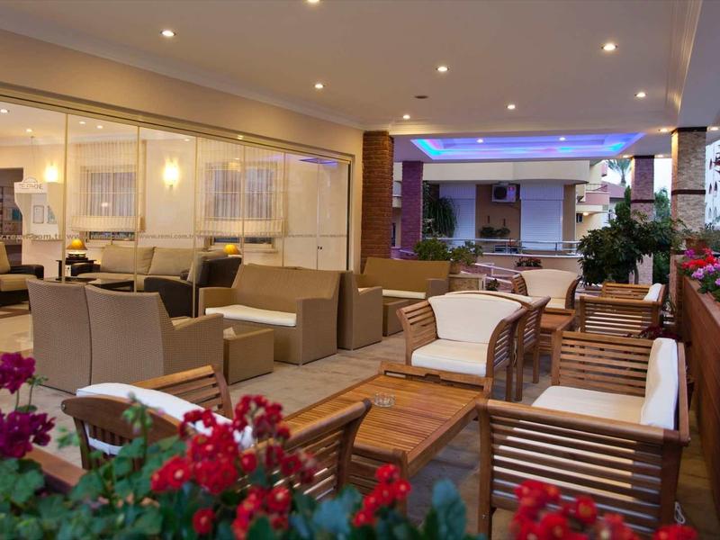 Terrasse d'hôtel élégante avec des espaces de sièges modernes et des plantes en fleurs.