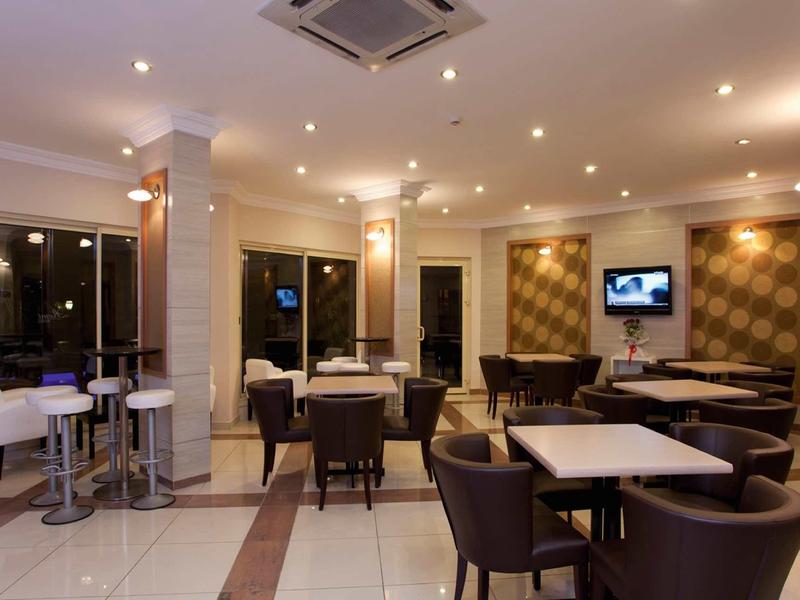 Bar d'hôtel moderne avec sièges confortables, tables et éclairage tamisé.