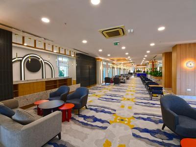 Modern hotel lobby area with comfortable seating and vibrant carpet design.