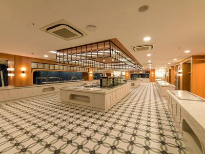 Spacious, well-lit hotel lobby area with geometric patterned floor and modern furniture.