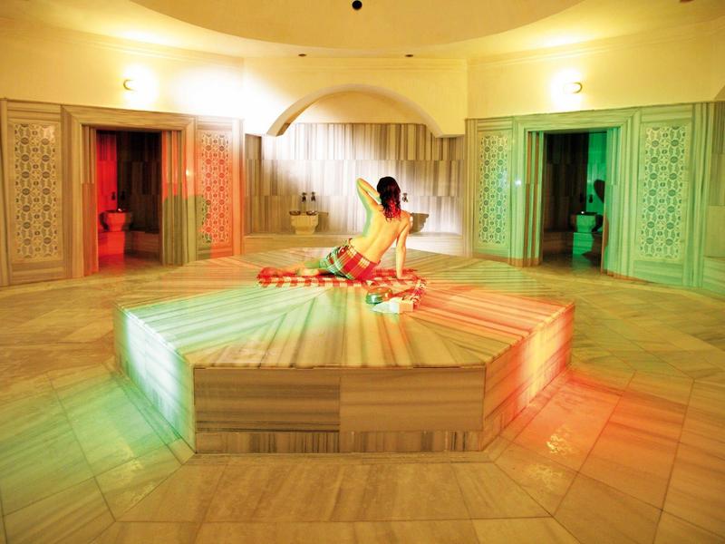 Jasne spa z centralną fontanną i marmurową podłogą, atmosfera zen i relaksu.