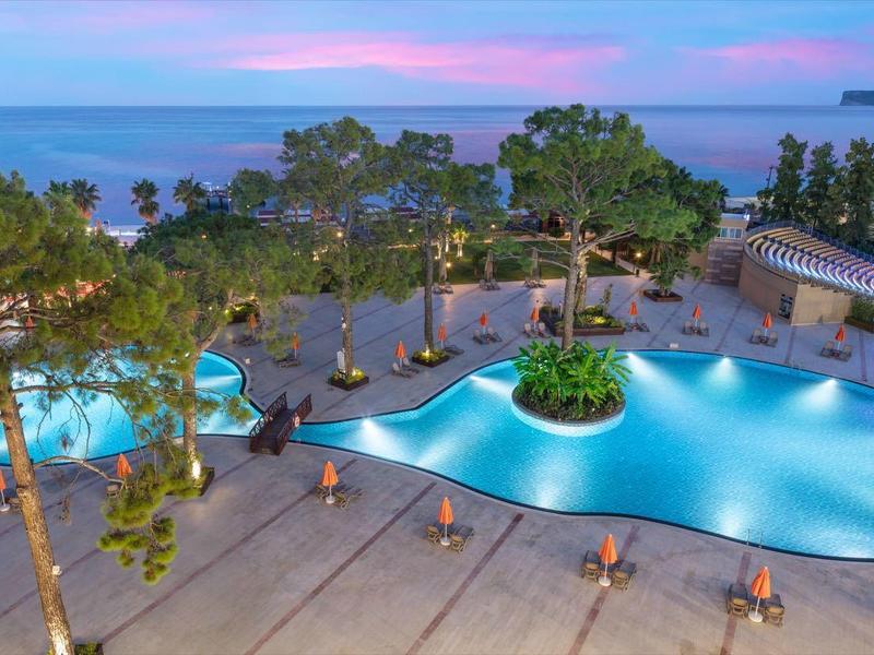 Zewnętrzny basen z oświetleniem nocnym w naturalnym otoczeniu blisko morza.