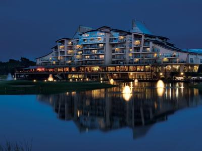 Modern hotel building by the lake with lighting and reflection in the water at night