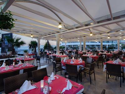 Area ristorante dell'hotel coperta con tavoli apparecchiati e sedie, pronta per gli ospiti.