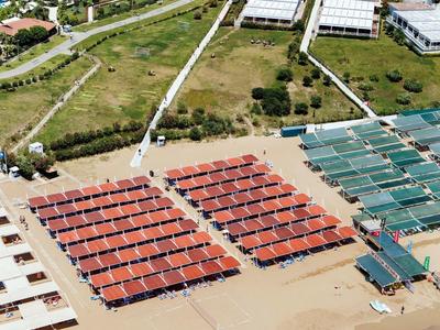 Přímořské letovisko s několika bazény, slunečníky a přístupem na písčitou pláž u moře.