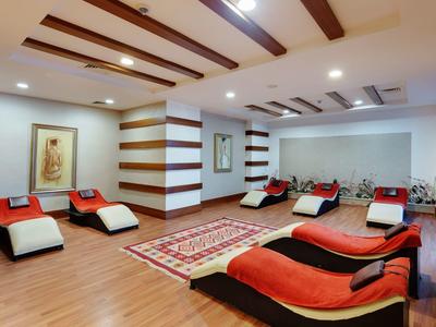 Moderní wellness místnost s pohodlnými lehátky, dřevěnou podlahou a uklidňujícím osvětlením.