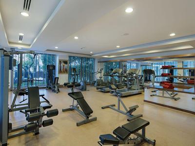 Moderne fitnessruimte met diverse trainingsapparatuur en grote ramen.