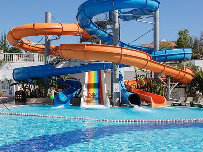 Scivoli d'acqua multicolori sopra una grande piscina in un resort.