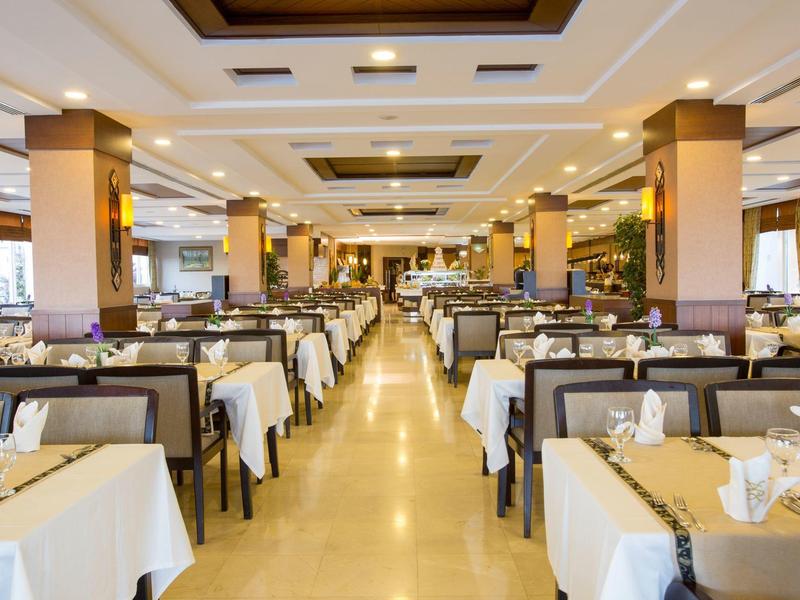 Ampia sala da pranzo con tovaglie bianche e tavoli ben apparecchiati.