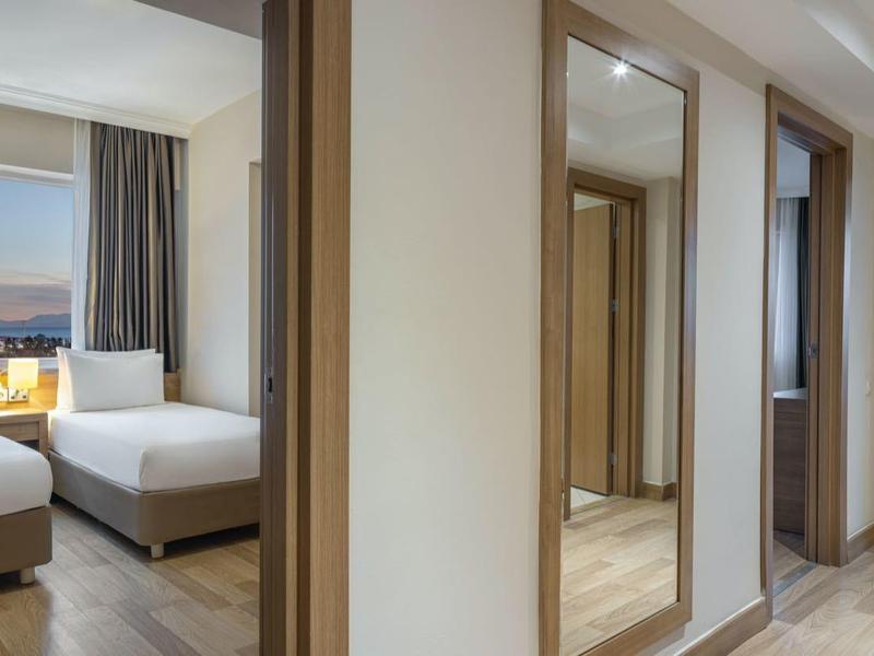 Moderní hotelový pokoj se dvěma jednolůžky, přirozeným světlem a světlým zařízením.