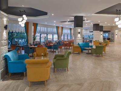 Lobby luminosa de hotel con sillones coloridos y grandes ventanas con vista al exterior.