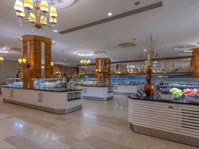 Grande salle de buffet lumineuse avec plusieurs îlots de nourriture et éclairage élégant.