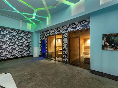 Moderní lázeňská místnost se saunou a modrozeleným akcentním osvětlením