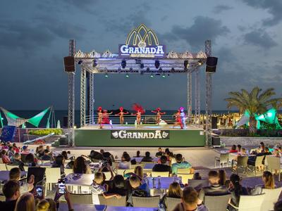 Evento serale con palco e pubblico all'aperto vicino a un hotel o resort