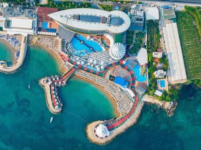 Hotelový komplex s bazény a dřevěnými moly nad tyrkysovým mořem.