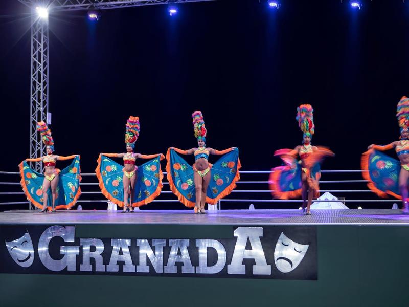 Barevní tanečníci na jevišti během představení na festivalu Granada.