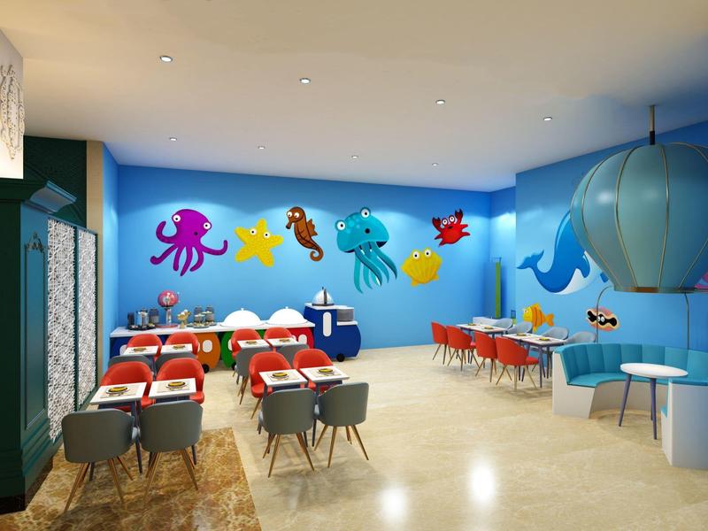 Barevná jídelna s mořskými dekoracemi, červenými stoly a šedými židlemi.