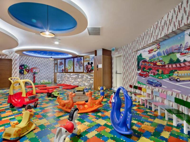 Barevná herna pro děti s hračkami a veselými dekoracemi.