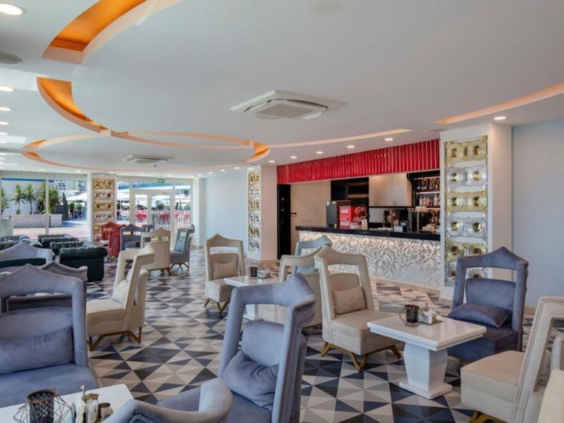 Interiér moderního hotelového salonku s pohodlnými křesly a osvětleným barem.