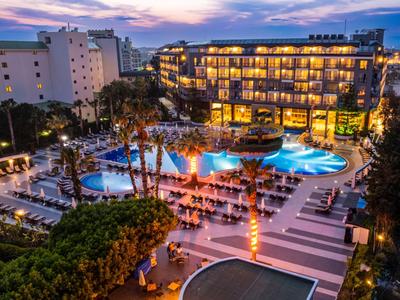 Hotel con piscina illuminata e sdraio al crepuscolo