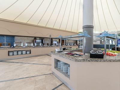 Bufetová část v restauraci s širokým výběrem jídel a talířů.