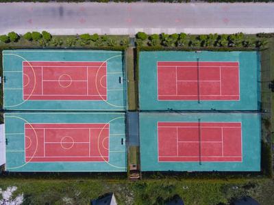 Quattro campi sportivi all'aperto con diverse marcature, circondati da erba, vista aerea.