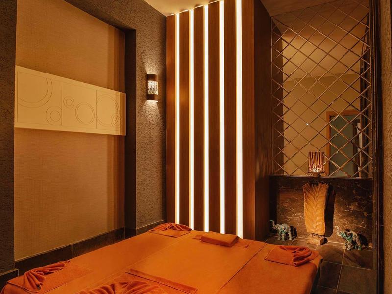 Gezellige wellnessruimte met massagetafel en warme ambiance.