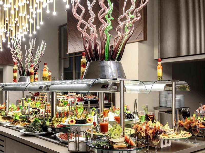 Elegantní bufet s různými pokrmy v moderní hotelové restauraci.