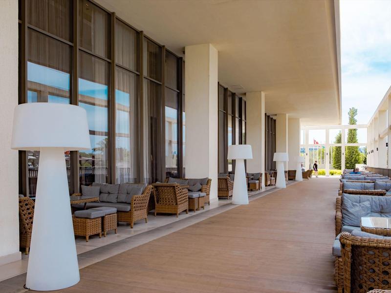 Zastřešená venkovní část s posezením a velkými moderními lampami v hotelu