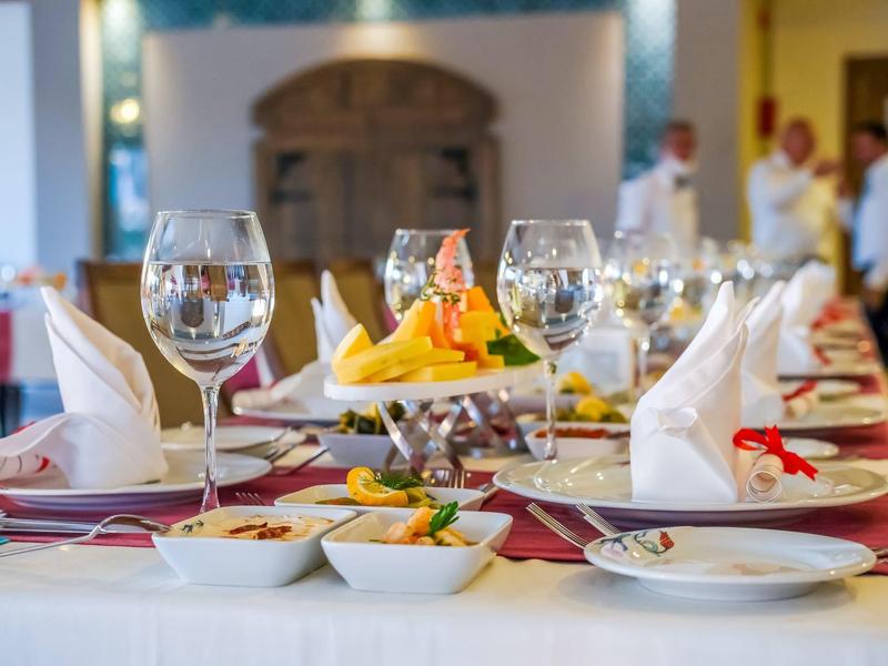 Elegantně prostřený stůl s sklenicemi a talíři pro slavnostní večeři.