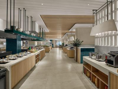 Moderner Hotel-Speisesaal mit Buffet, gedeckten Tischen und stilvollem, hellem Ambiente.