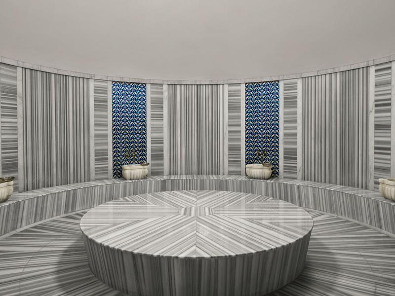 Interiér kulaté, moderní turecké lázně se šedými mramorovými povrchy a centrálním sedacím blokem.