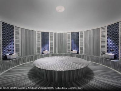 Área de spa moderna con mesa central redonda de madera y paredes azulejadas oscuras con nichos para sentarse.