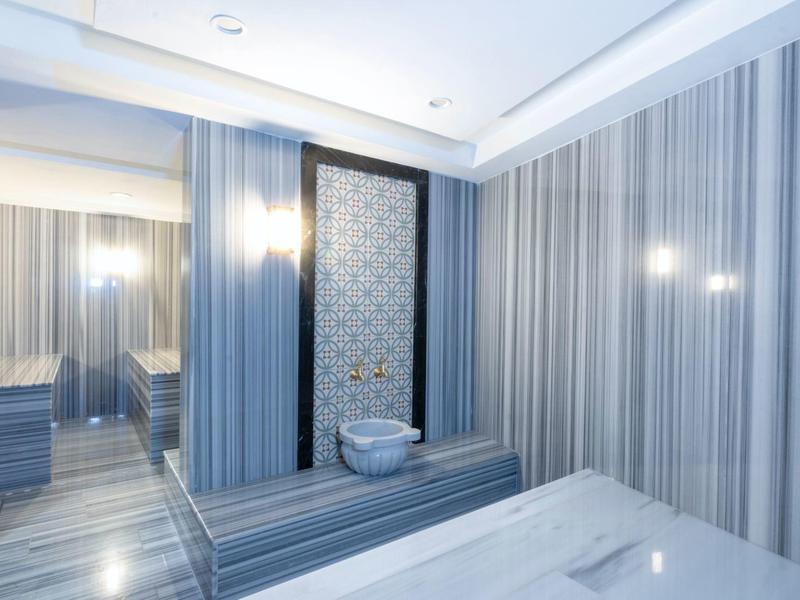 Moderní koupelna s pruhovanými dlaždicemi a zabudovaným záchodem v neutrálních barvách.