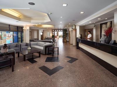 Großer Hotel-Lobby mit Empfangstresen, Sitzbereichen und modernem Interieur.