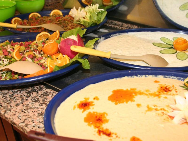 Diverse kommen met kruiden en ingrediënten op een tafel, versierd met bloemen.