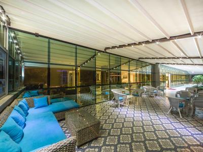 Area esterna coperta con posti a sedere e pavimento decorato di notte.