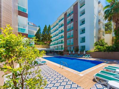 Moderner Innenhof mit rechteckigem blauen Pool, Liegestühlen und umliegenden Wohngebäuden.