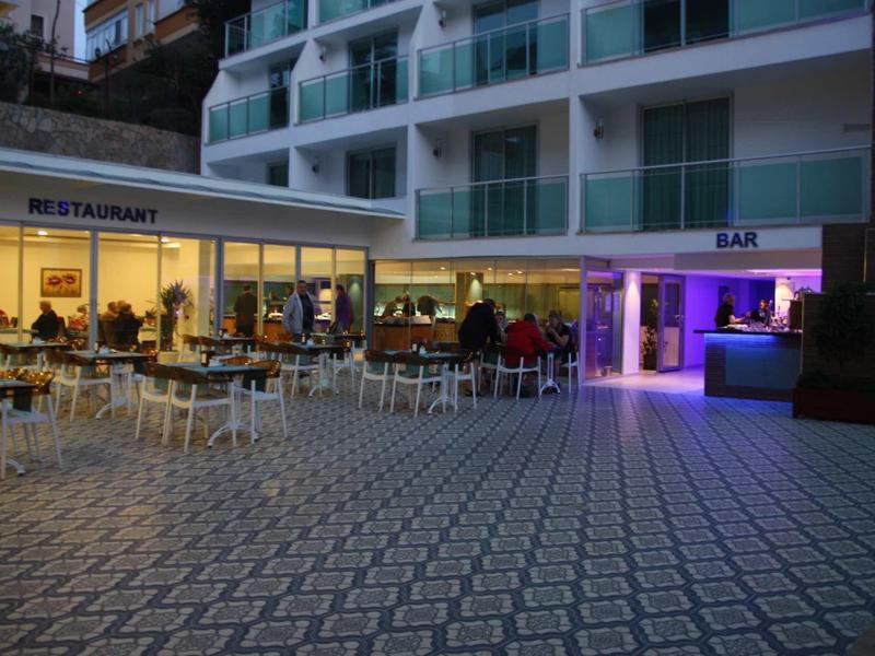 Abendstimmung im Außenbereich eines Restaurants mit Sitzplätzen und rundem Bartresen.