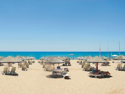Spiaggia con lettini e ombrelloni davanti al mare calmo e cielo sereno